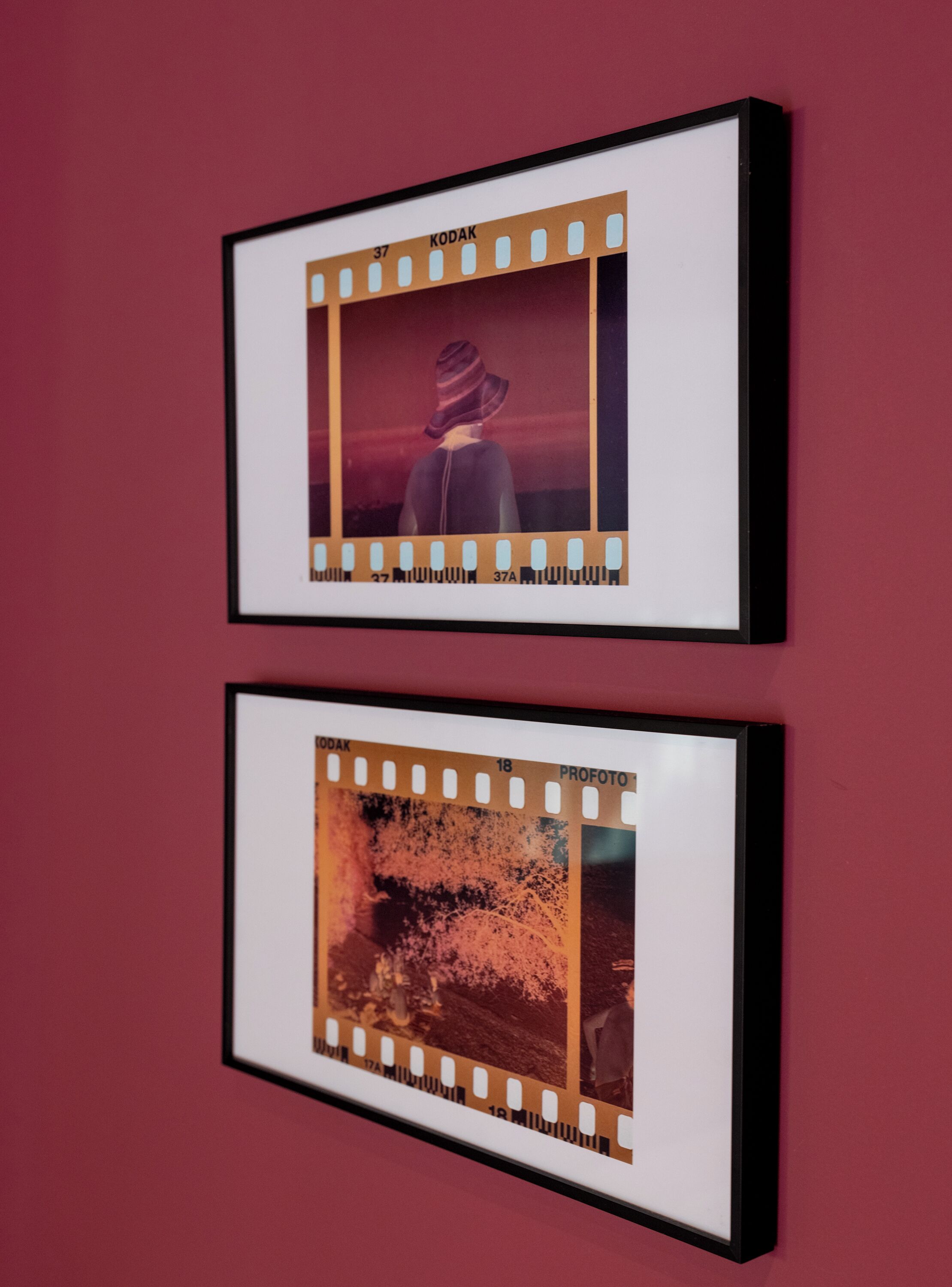 Twee ingelijste foto's aan een muur.