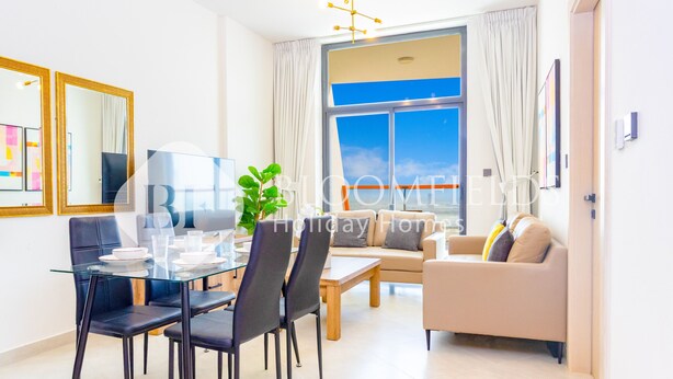 Un salon moderne avec une table à manger en verre, des chaises noires, un canapé beige et une grande fenêtre avec des rideaux.