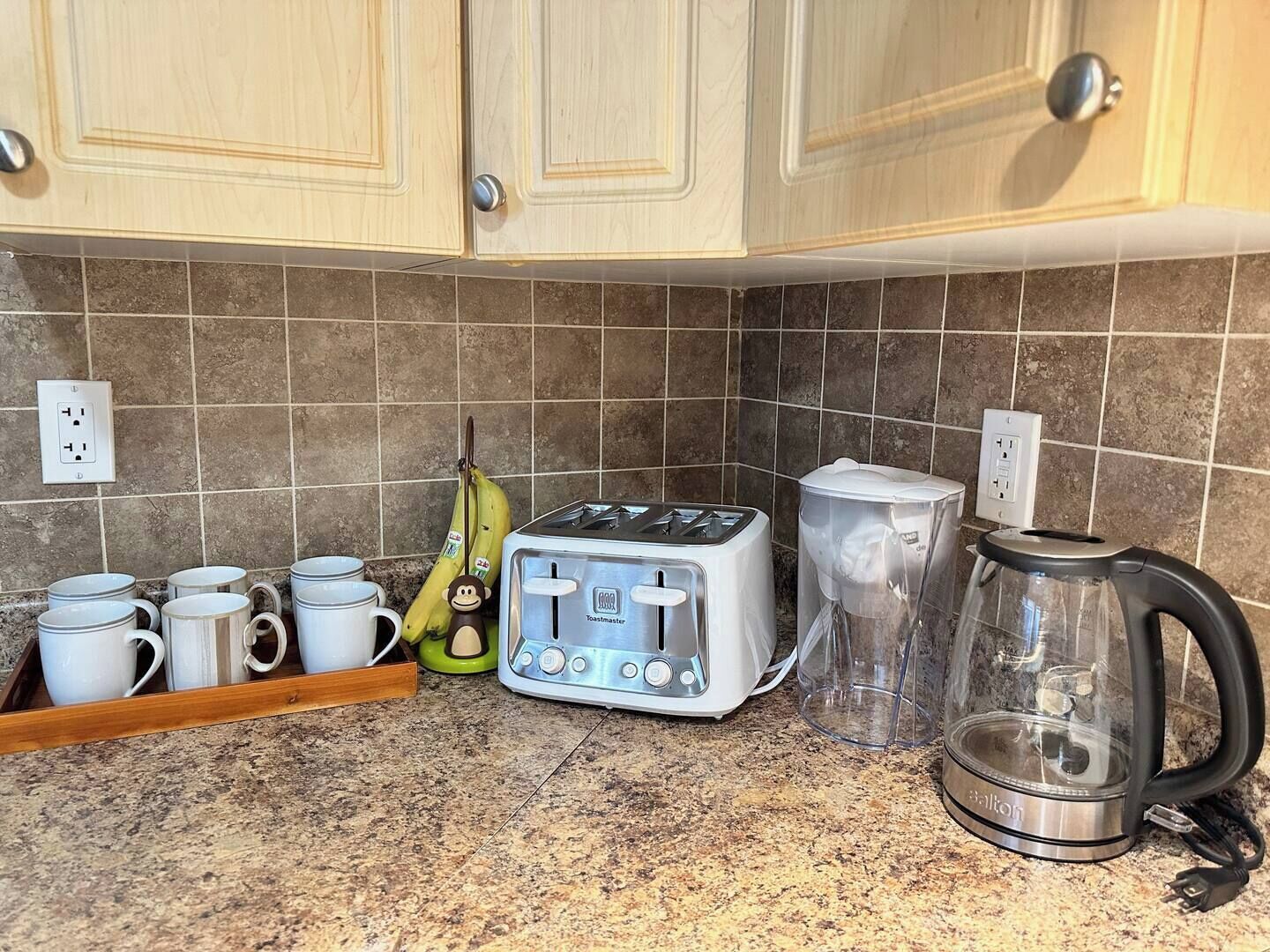 Eine Küche mit einem Toaster, einer Kaffeemaschine und einer Banane auf der Arbeitsfläche.