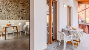 Ein Essbereich mit Steinwand, Holzbalken und einem Balkon mit Tisch für zwei Personen.