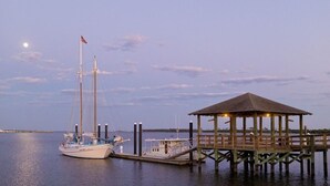 A dock with a sailboat and a wooden gazebo. - Old Spanish House Vivian Suite A. Sophisticated Retreat, Beach, Fire Pit, Downtown, Golf Cart (Biloxi)