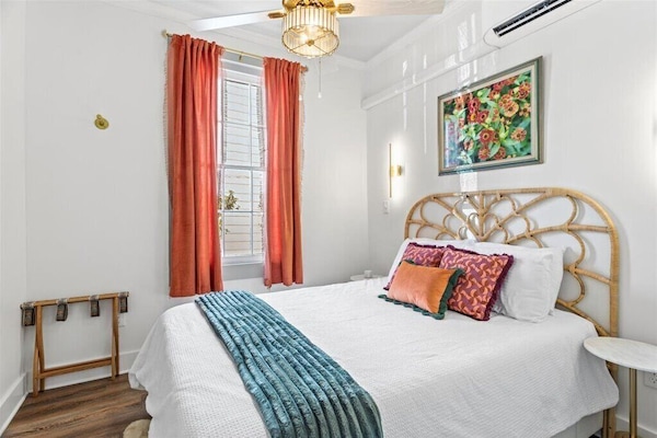 Cozy pillows and throw complement colorful local art above this queen-sized bed. You'll rest well amid these luxurious linens!