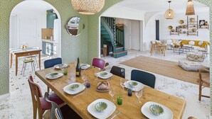 Ein Essbereich mit einem Holztisch, der für eine Mahlzeit gedeckt ist, umgeben von Stühlen.