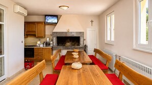 A modern kitchen with wooden cabinets, a built-in oven, and a television. - Holiday Home Nadalina (Vrgorac)