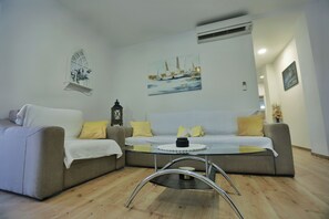 A living room with a sofa set, a coffee table, and a painting on the wall. - Holiday Home Amaya (Vrgorac)