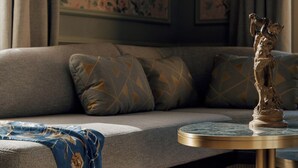 Un salon moderne avec un canapé, une table basse ronde et une statue décorative.