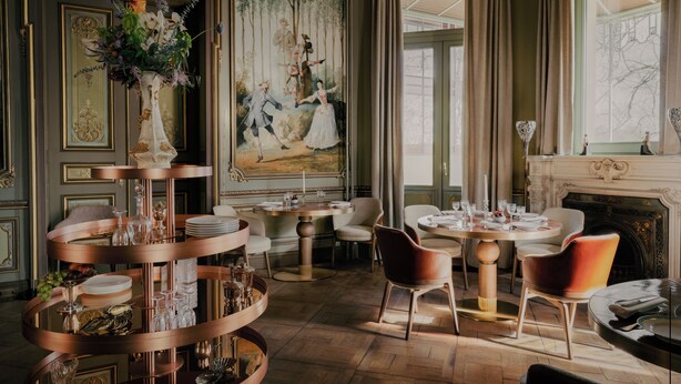 Une salle à manger luxueuse, agrémentée de décorations raffinées, d’un grand tableau et d’une cheminée.