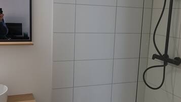 Een douche, handdoeken, toiletpapier