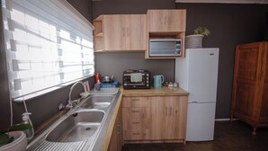 Una cucina compatta con lavandino, forno a microonde, tostapane e frigorifero.