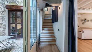 Un escalier menant à un deuxième étage, avec un mur en pierre et un plancher en bois sur la plateforme.