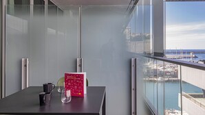 Un balcone con un tavolo, un libro e un bicchiere.