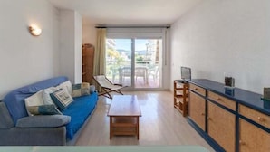 Ein modernes Wohnzimmer mit einer Couch, einem Holztisch und einem Fernseher.