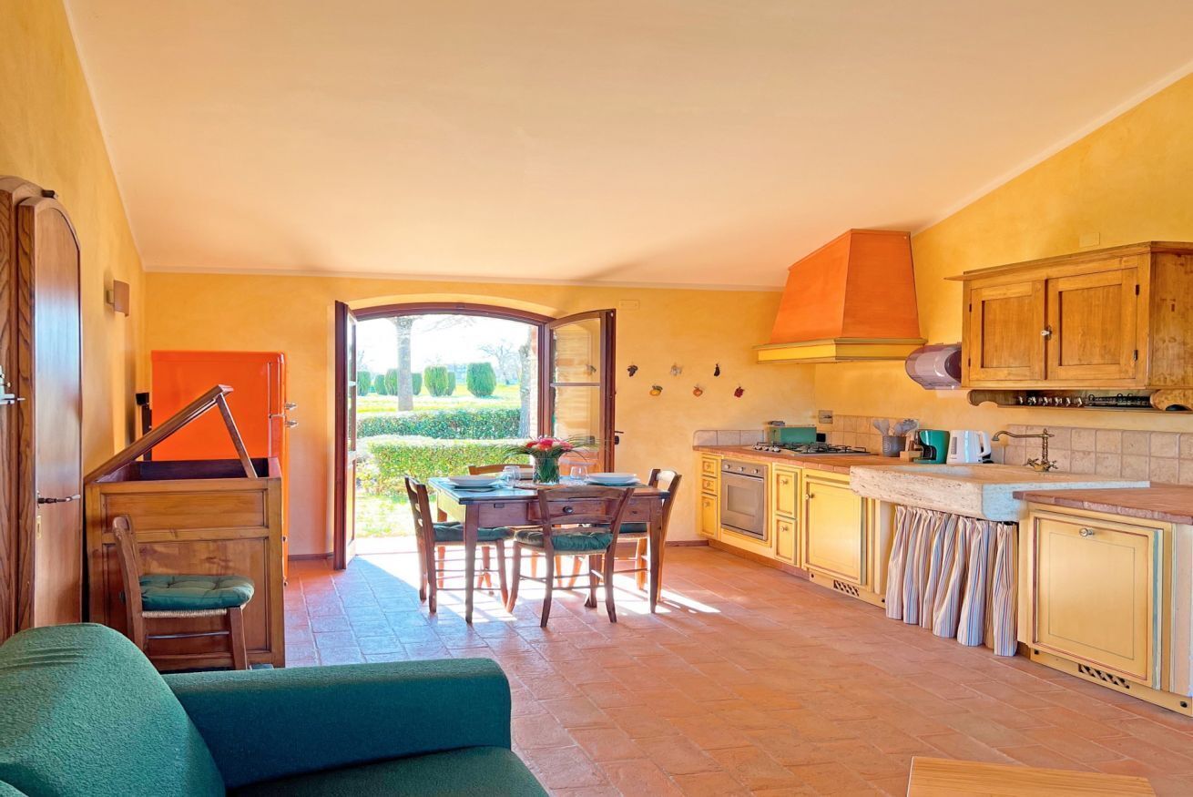 A spacious kitchen with a dining area, a sofa, and a view of the garden.