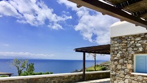 A stone building with a stone wall and a view of the sea.