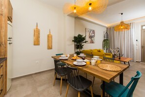 A dining area with a wooden table, black chairs, and a yellow sofa.