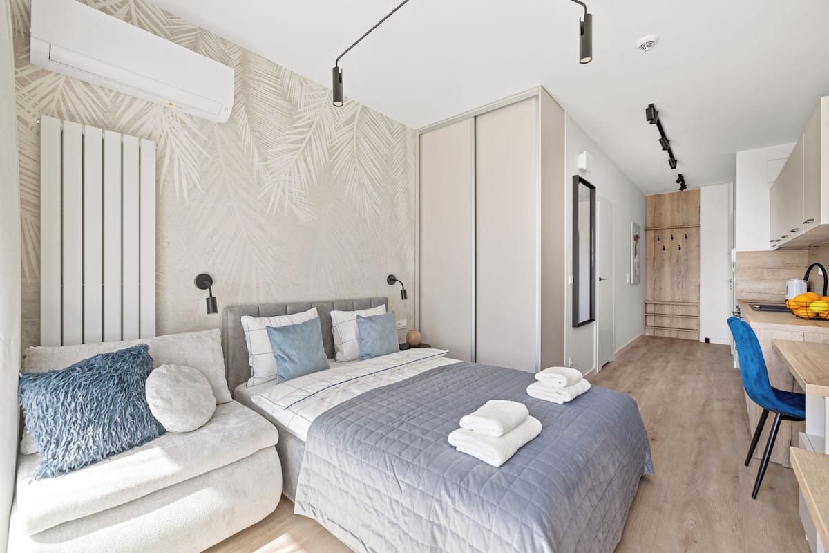 A modern bedroom with a bed, bedside tables, a desk, and a chair.