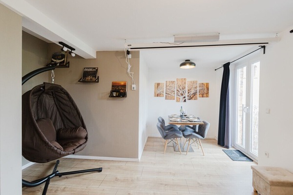 Relaxation corner with stylish swing chair and view into dining area.