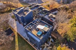 A modern multi-story residential building with a rooftop deck, outdoor seating area, and a swimming pool. - Luxury Hot tub Rooftop Deck Game Room Nashville (Nashville)
