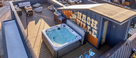 Terraza en la azotea con jacuzzi, zonas de estar y un mural.