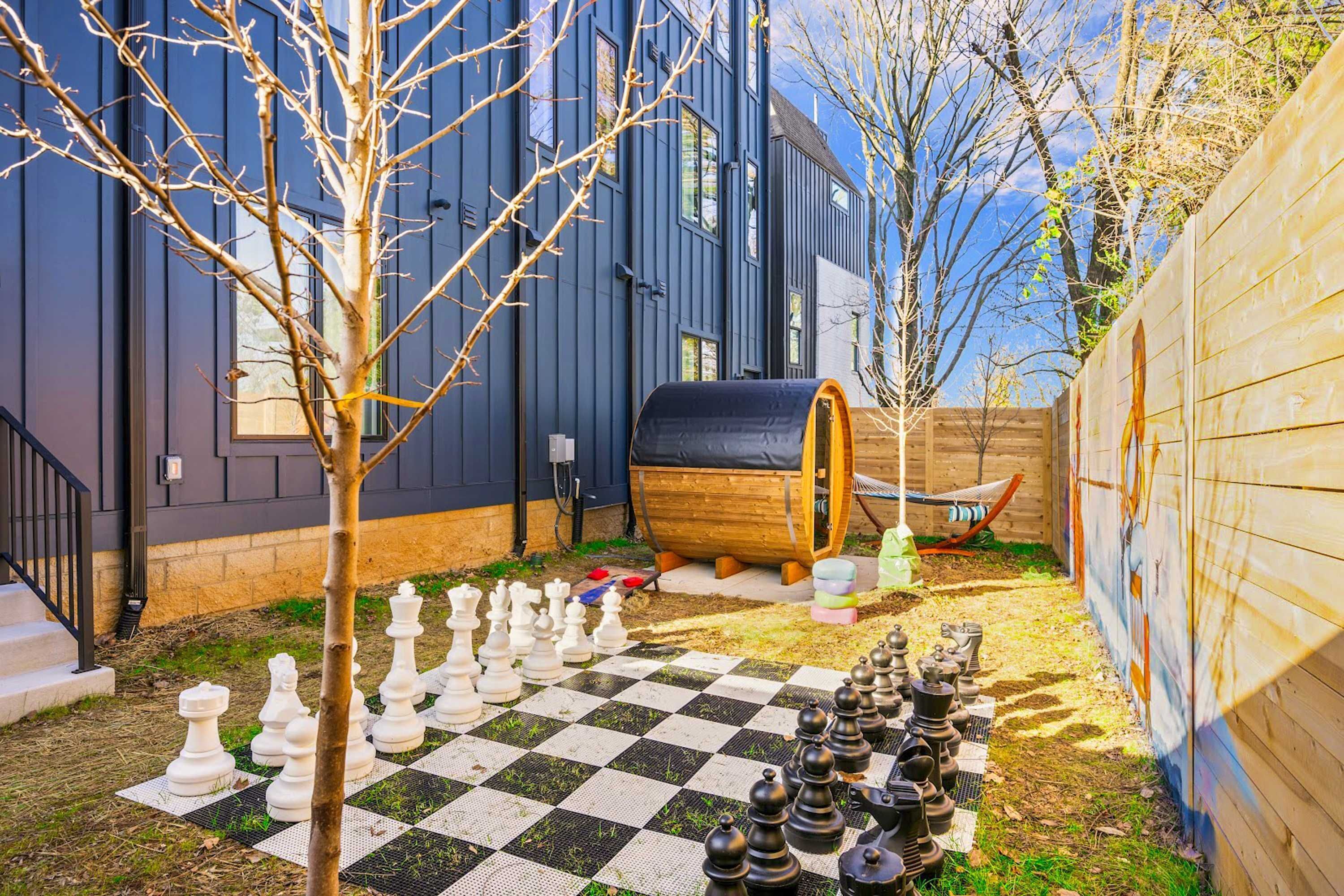 A chessboard set up in a backyard with a house in the background.