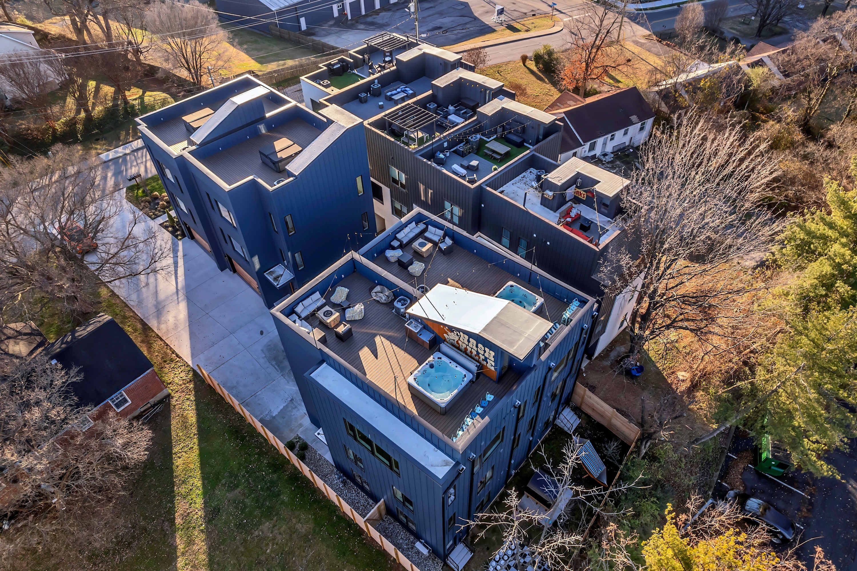 A modern multi-story building with a rooftop deck, large windows, and a flat roof.