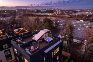 A rooftop terrace with a hot tub, seating area, and string lights. - Hot Tub Game Room Rooftop Downtown Nashville (Nashville)