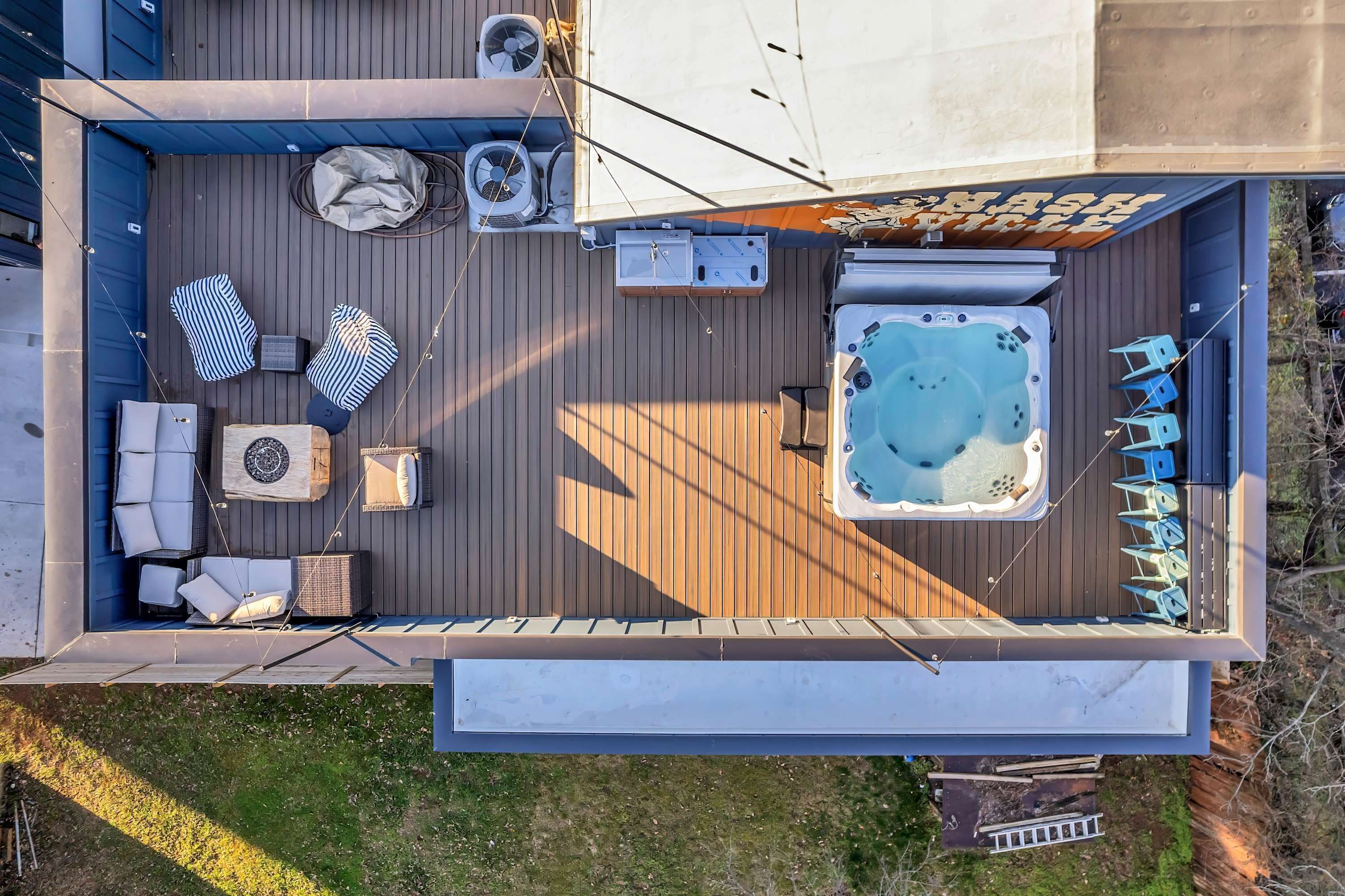 A deck with a hot tub, lounge chairs, and a covered seating area.