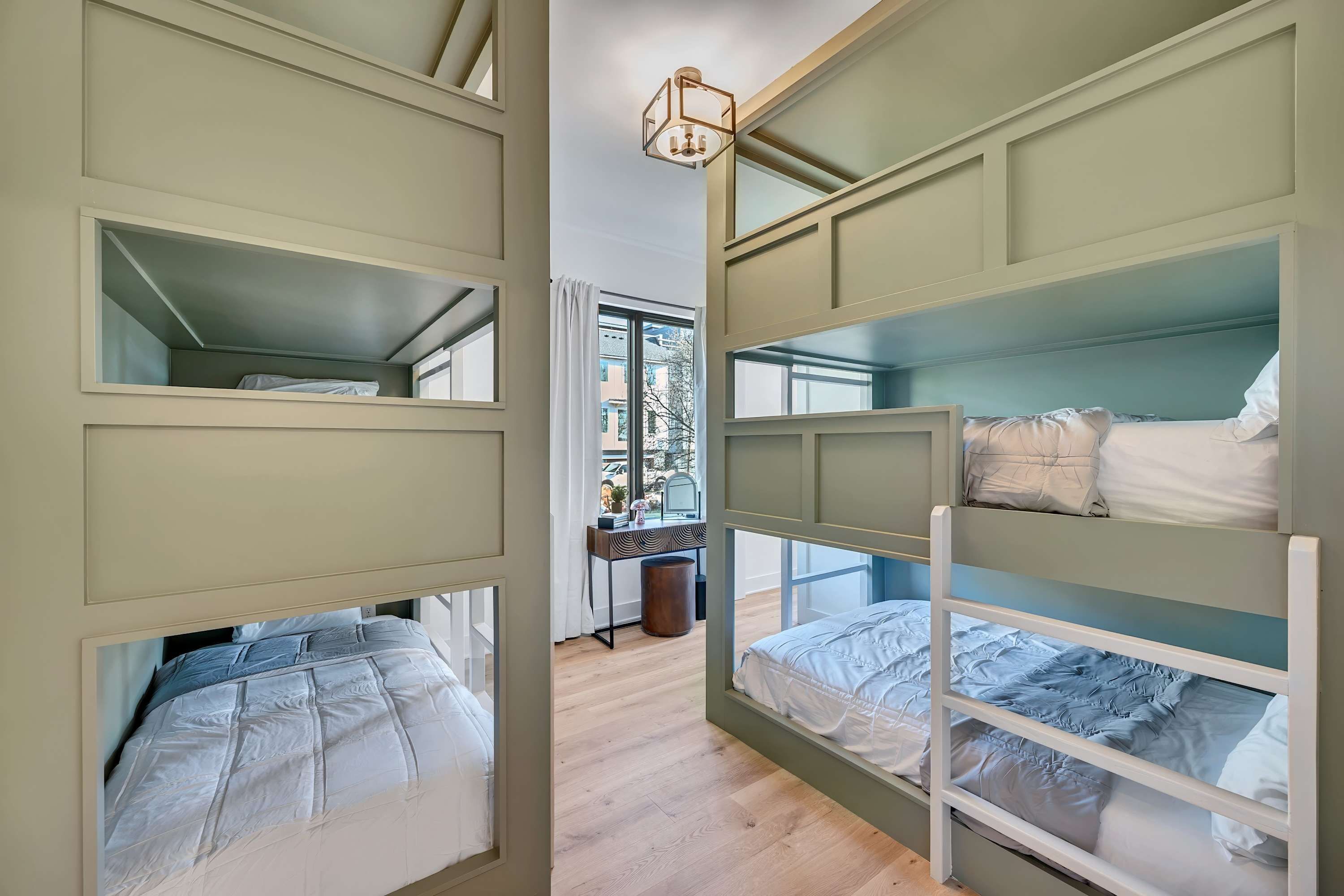 Camera con letto a castello, scrivania e finestra.