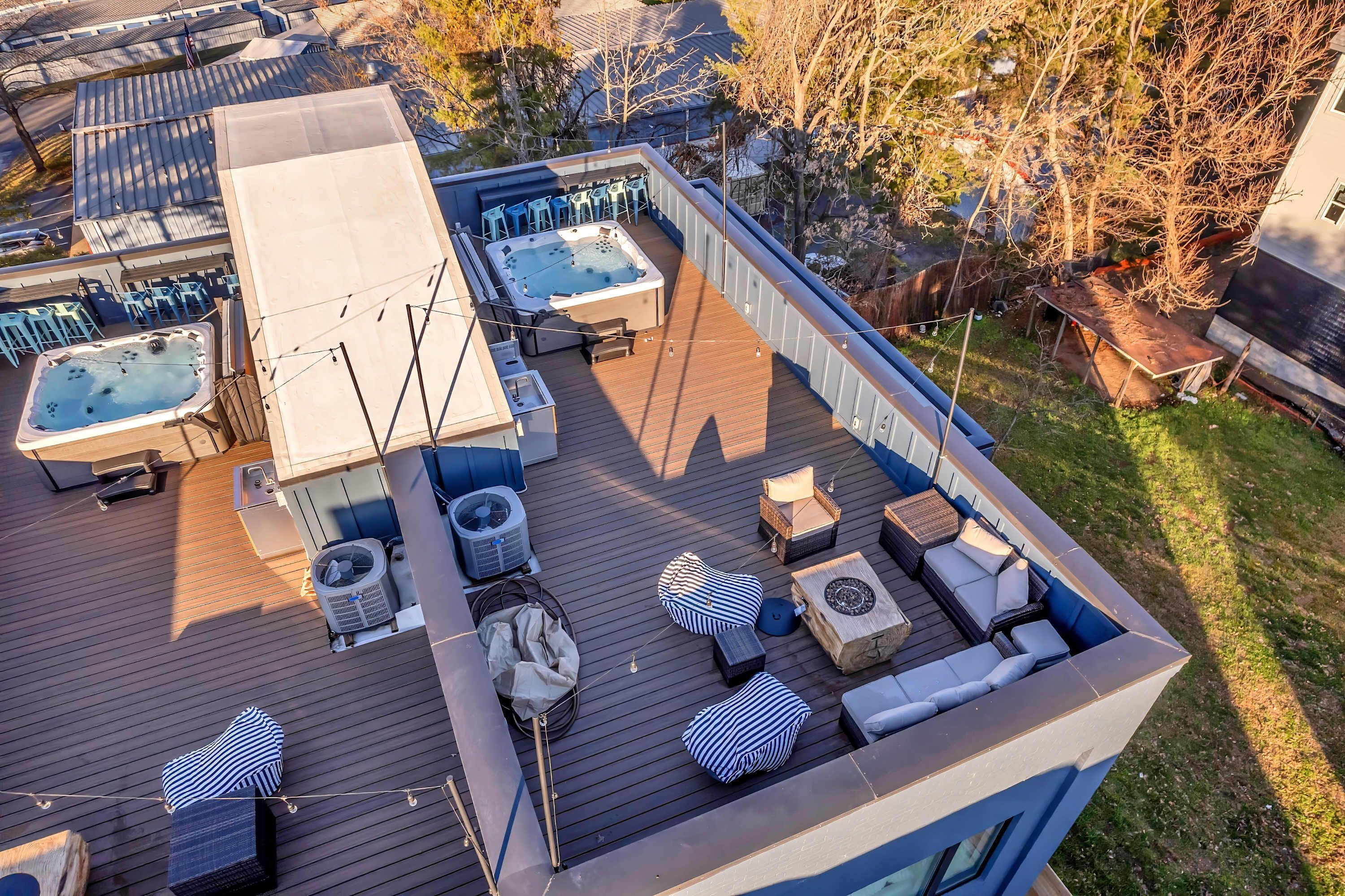 Eine Dachterrasse mit Whirlpool, Sitzbereich und Gartenmöbeln.