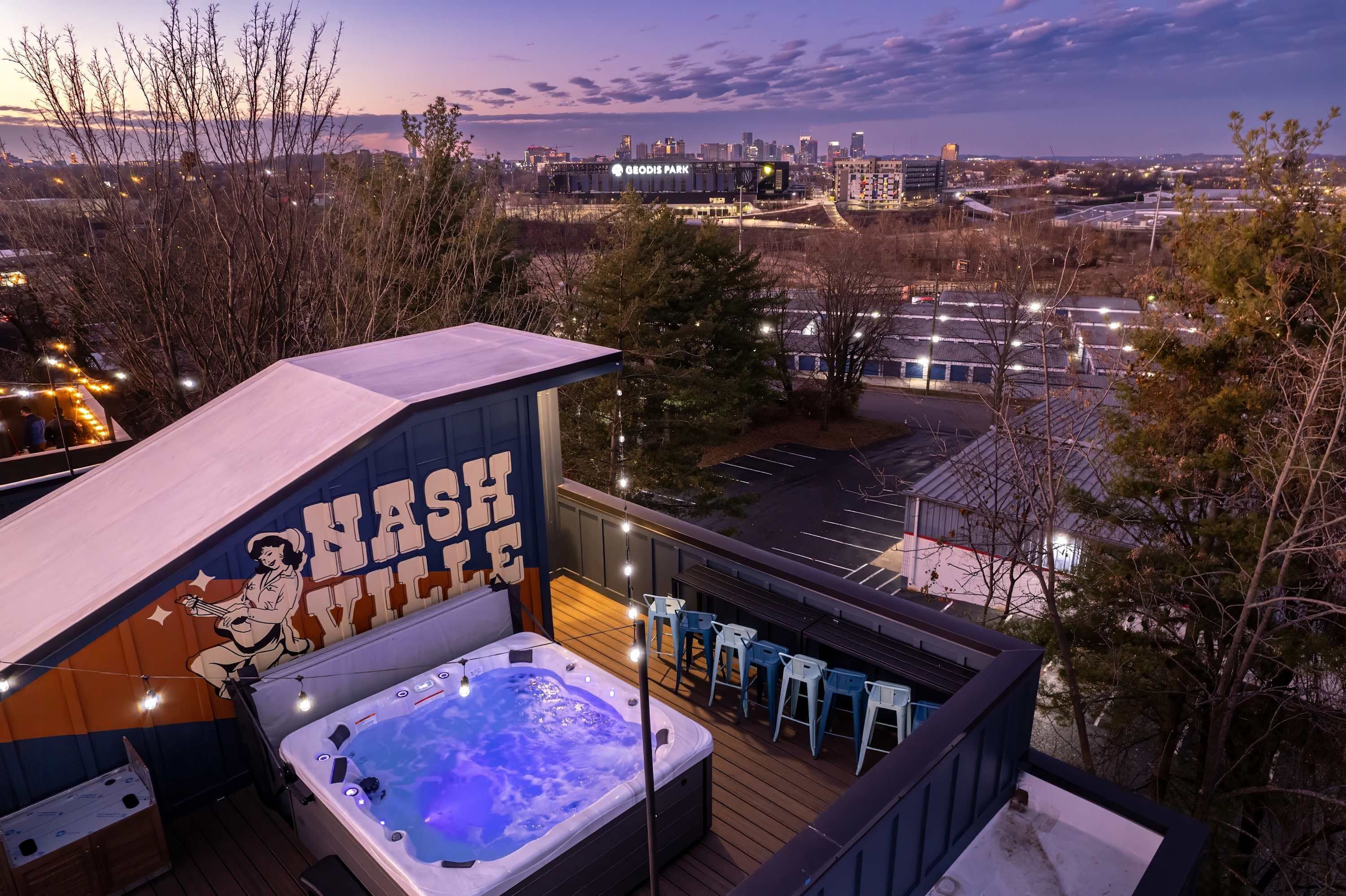 Terraza en la azotea con jacuzzi, asientos exteriores y vistas al horizonte de la ciudad.
