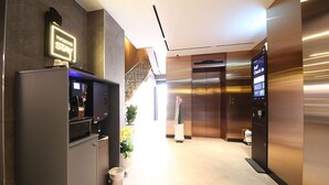 A modern hotel lobby with a self-check-in kiosk, an elevator, and a staircase. - Jeonju Hotel Twosome Stay Seosin (Jeonju)