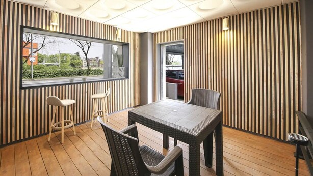 A modern dining area with a wooden floor, a large window, and a view of the outside. - Jeonju Hotel Twosome Stay Seosin (Jeonju)