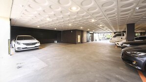 A parking garage with a modern ceiling design, concrete floors, and multiple parked cars. - Jeonju Hotel Twosome Stay Seosin (Jeonju)