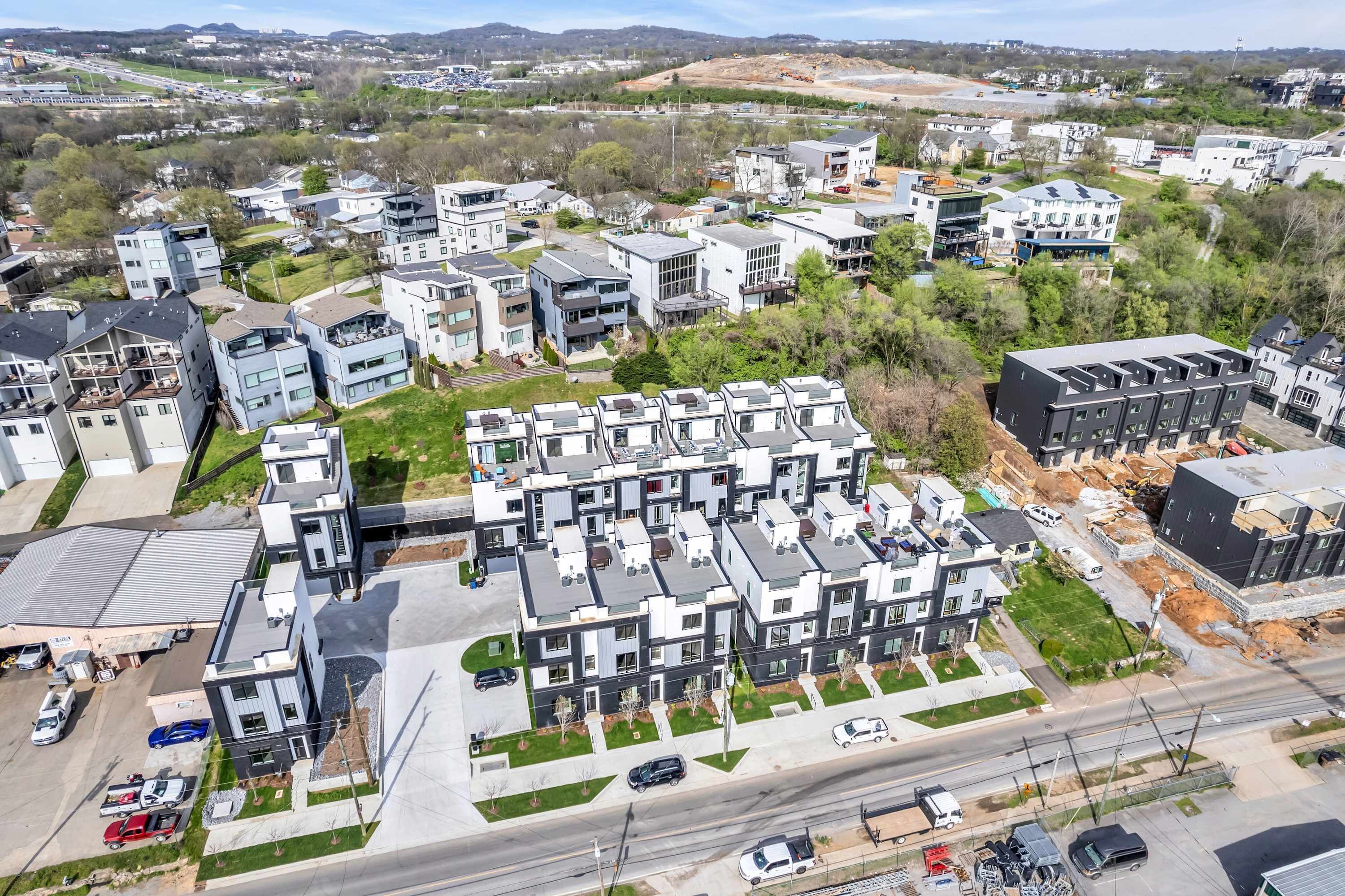 Un quartier résidentiel moderne, avec des immeubles d’appartements au design contemporain, des pelouses bien entretenues et des routes dégagées.