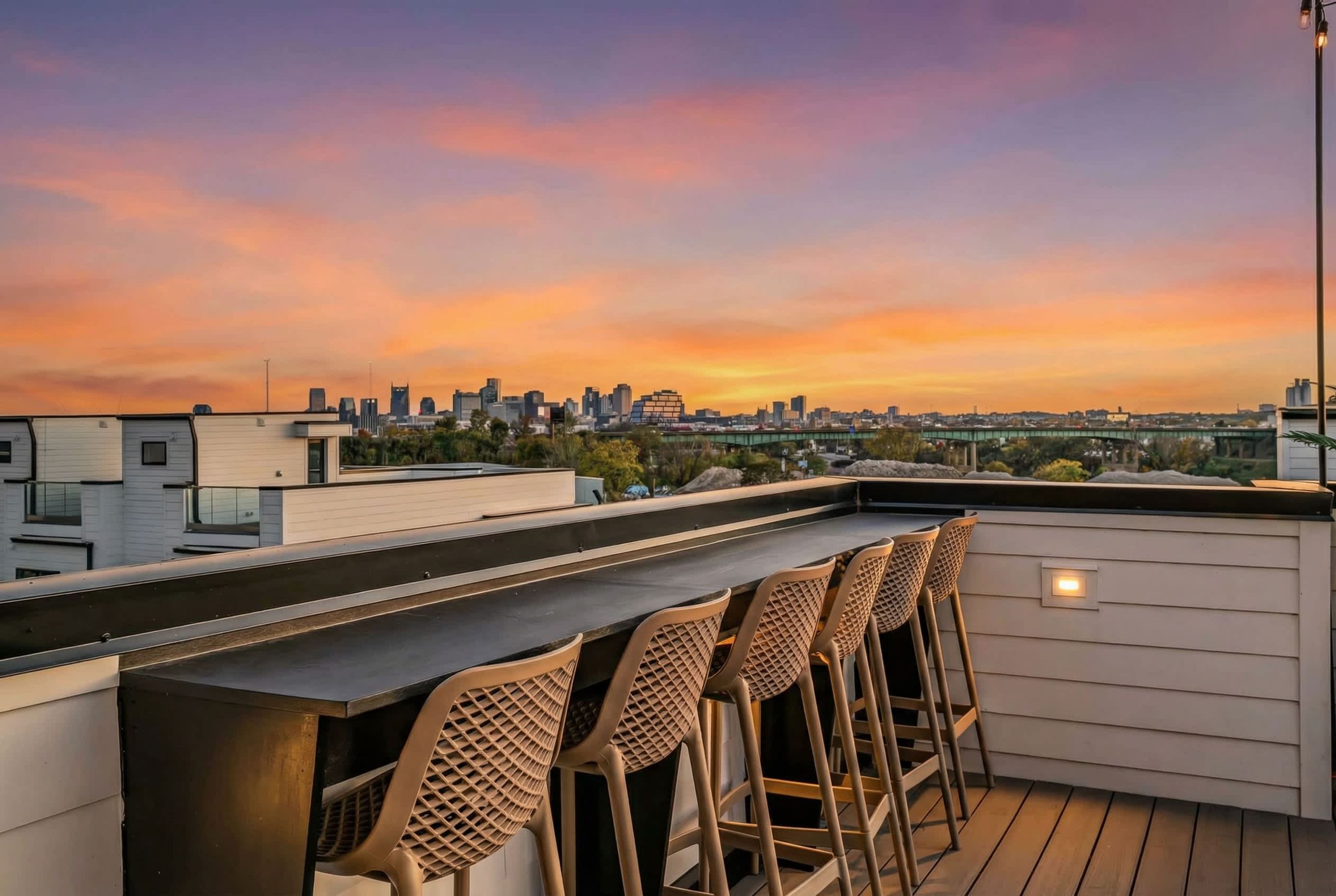 Un bar sul tetto con vista sullo skyline cittadino al tramonto.