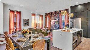 A modern kitchen with a central island, dark cabinetry, and stainless steel appliances. - Disco Lounge Double Rooftop Hot Tub Nashville (Nashville)