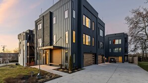Uma casa moderna de dois andares com garagem, entrada por automóvel e gramado bem cuidado.