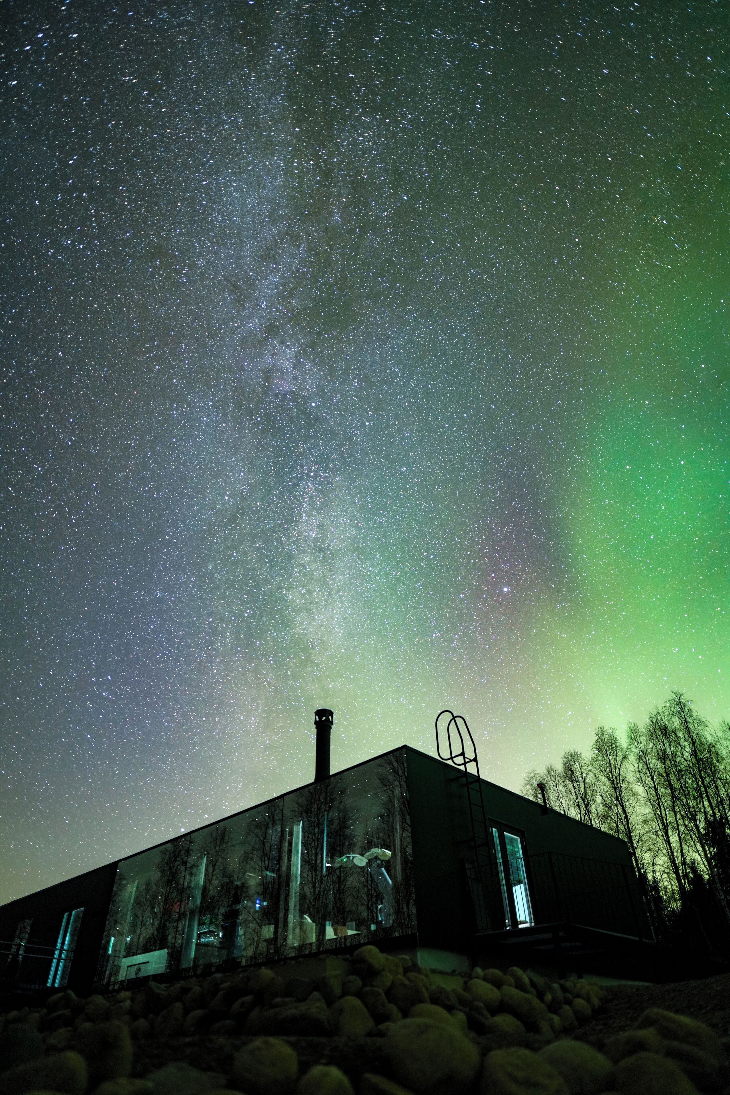 A building with a starry night sky and the aurora borealis.