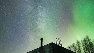 A building with a starry night sky and the aurora borealis.
