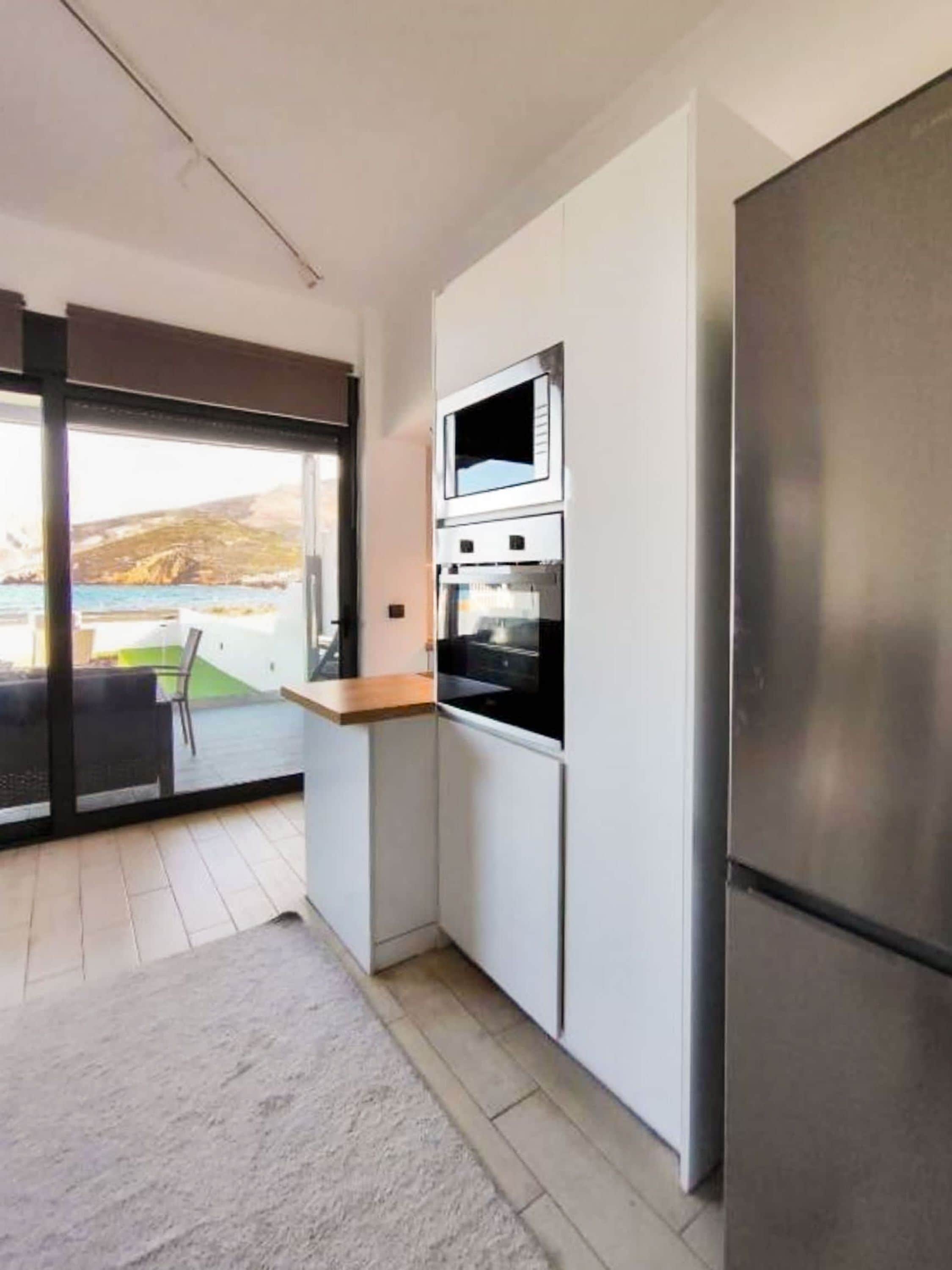 A modern kitchen with a stainless steel refrigerator, a microwave, and an oven.