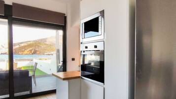 A modern kitchen with a stainless steel refrigerator, a microwave, and an oven.