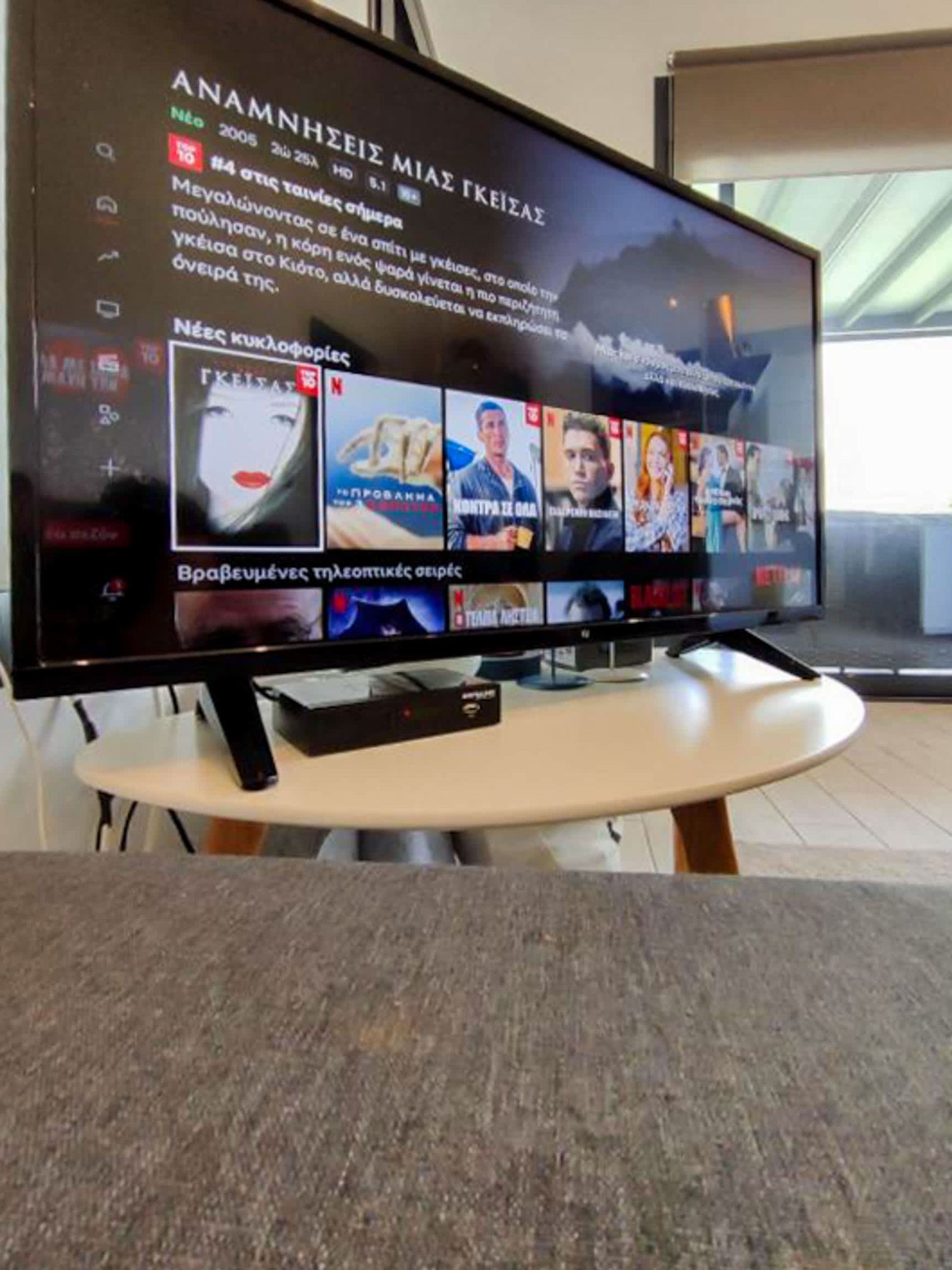 A television displaying a selection of movies and TV shows, with a menu interface in a foreign language.