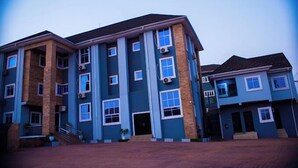 A multi-story residential building with a brick facade and multiple windows. - LAGENDA HOTELS (Enugu)