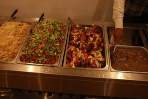 A buffet with various dishes including a casserole, a salad with mixed vegetables, a pasta dish, and a meat dish. - LAGENDA HOTELS (Enugu)