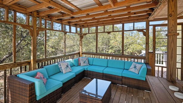 Un área de estar al aire libre cubierta con un amplio sofá modular y una mesa de centro.