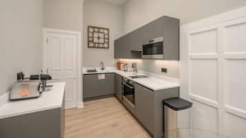 A modern kitchen with grey cabinetry, a built-in oven, and a microwave.