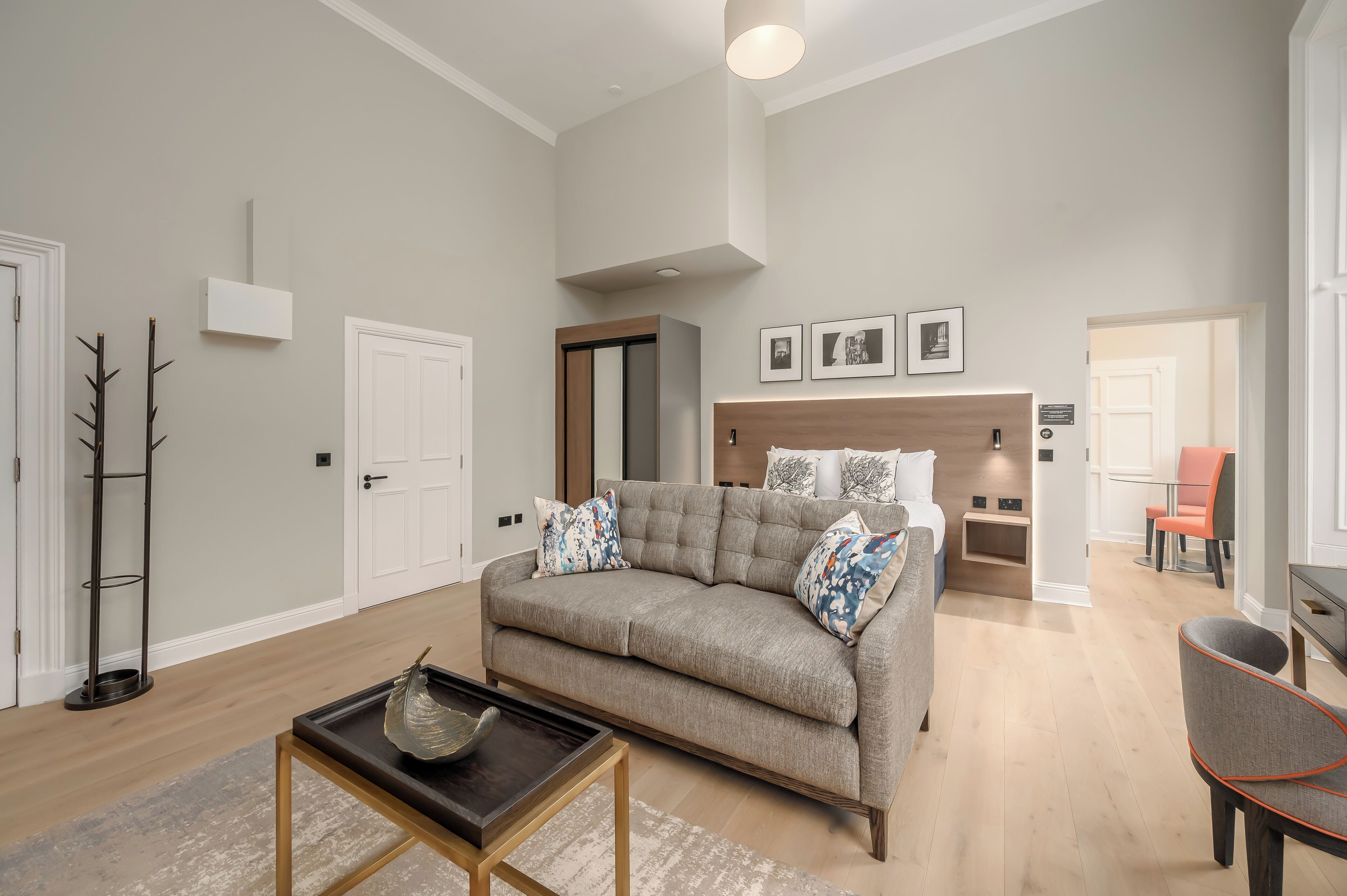 A modern living room with a sofa, coffee table, and a dining area with a chair.