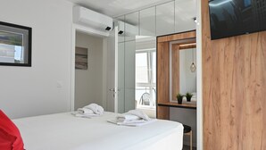 A modern bedroom with a bed, a TV, a mirror, and a glass door leading to a balcony. - Nova Luxury Residence apartment with private heated pool (Novalja)