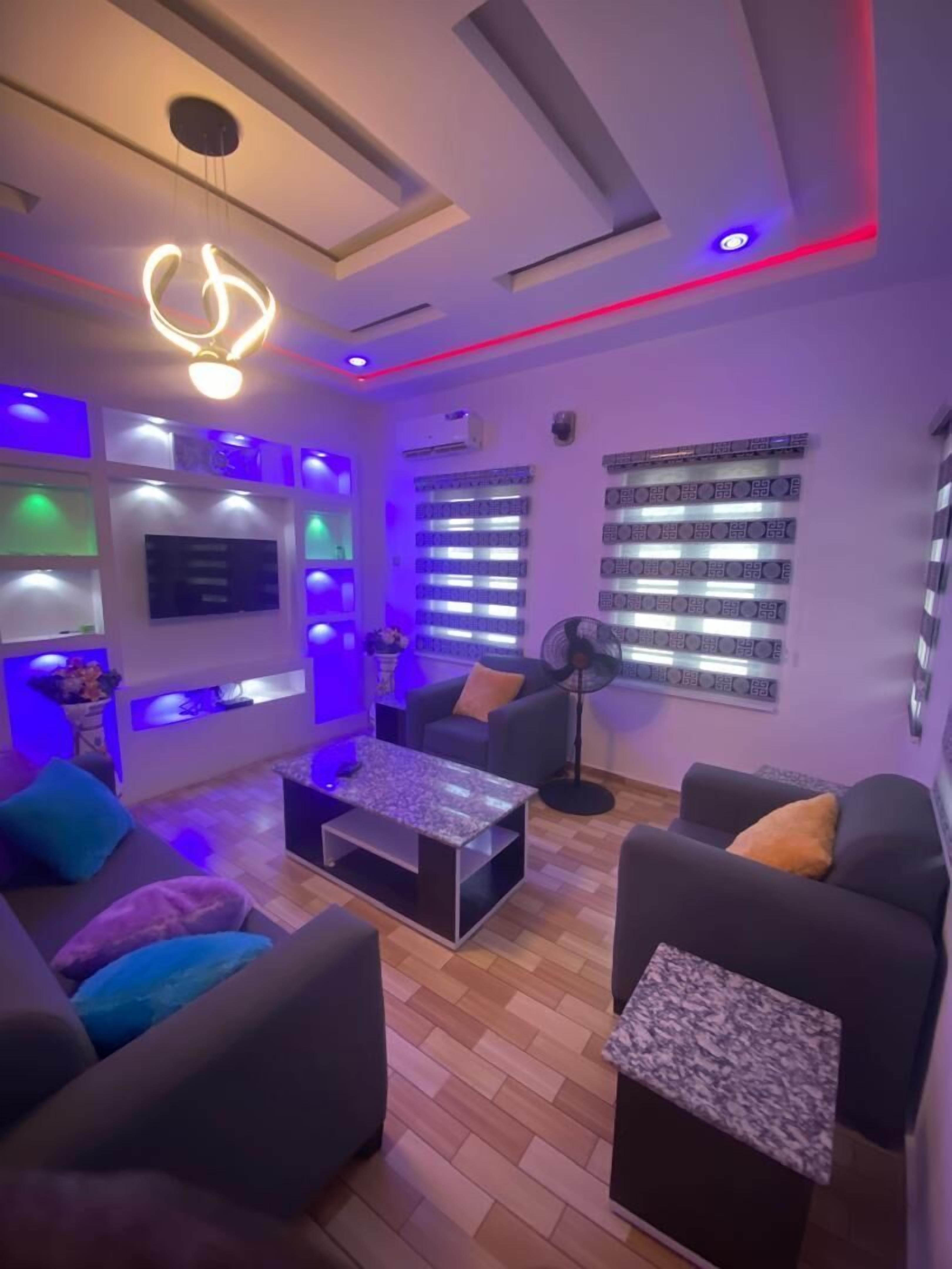 A modern living room with a sofa, coffee table, and a TV mounted on the wall.