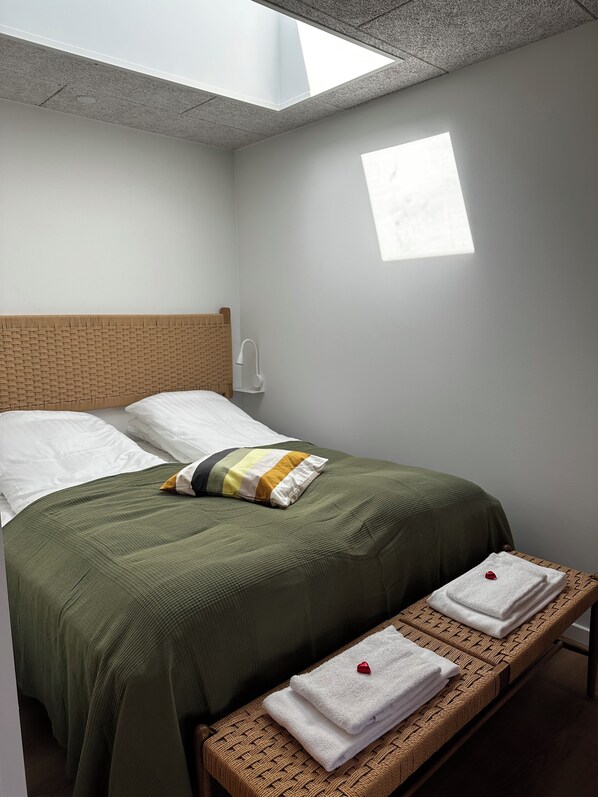 A room with a bed, a bench, a skylight, and a small window. - Hygge Strand Camping (Odder)